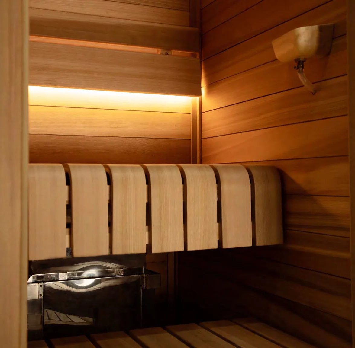 SAWO Helius Mini heater installed hidden behind a sauna bench