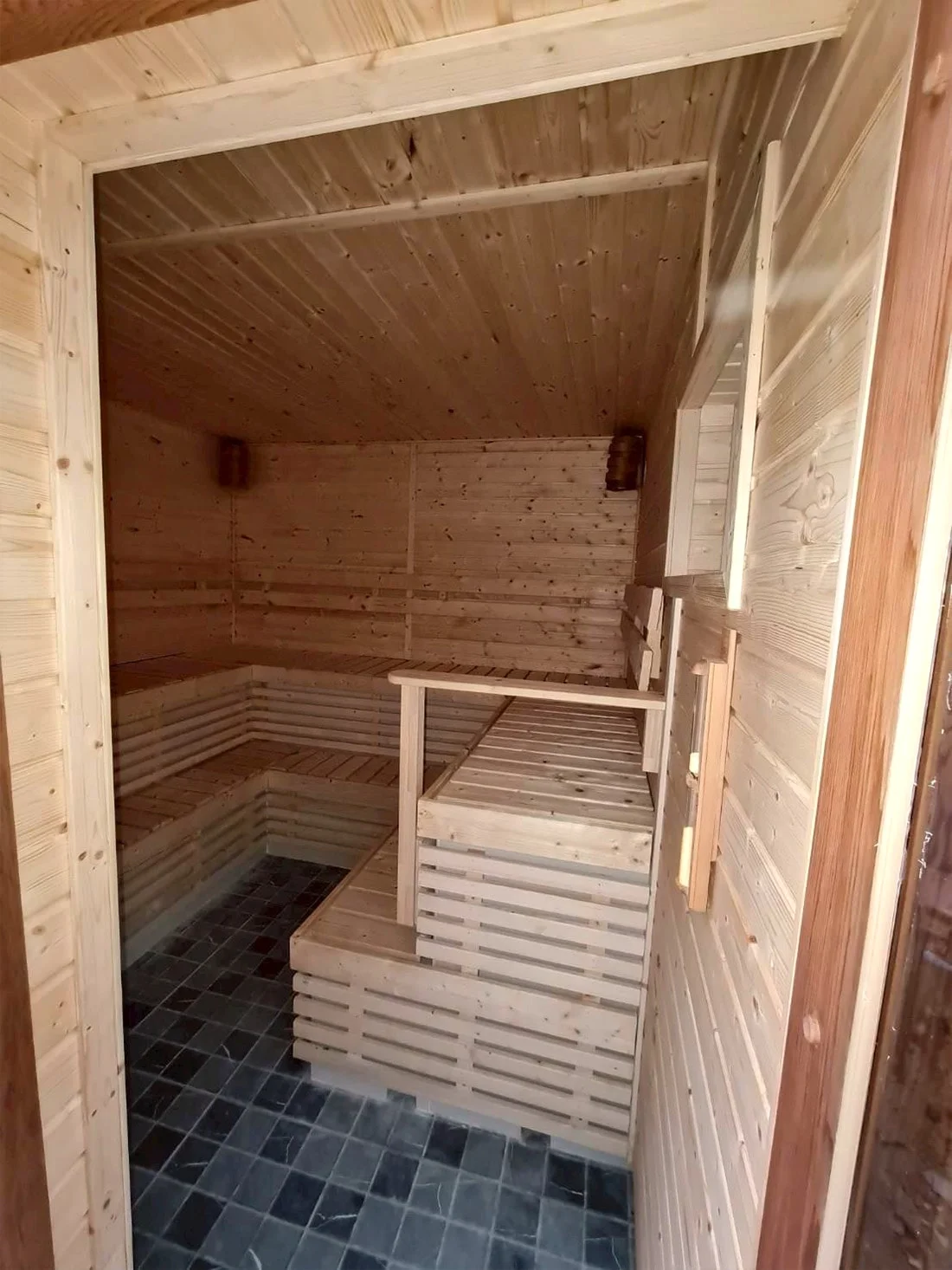 Sauna interior with tiered benches in pale timber