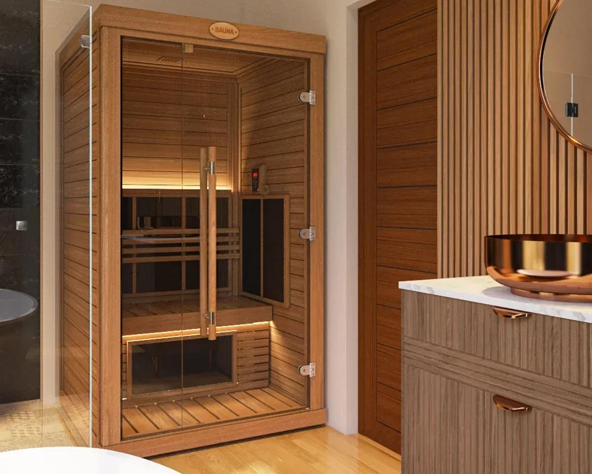 Compact SAWO sauna cabin with a full glass front, lit benches inside, standing in a timber-panelled bathroom